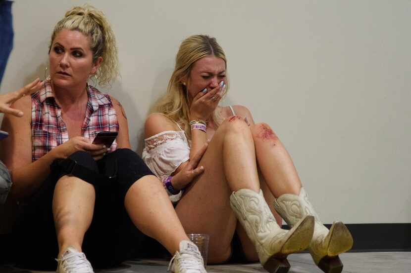 A woman cries while hiding inside the Sands Corp. plane hangar after Sunday's mass shooting...
