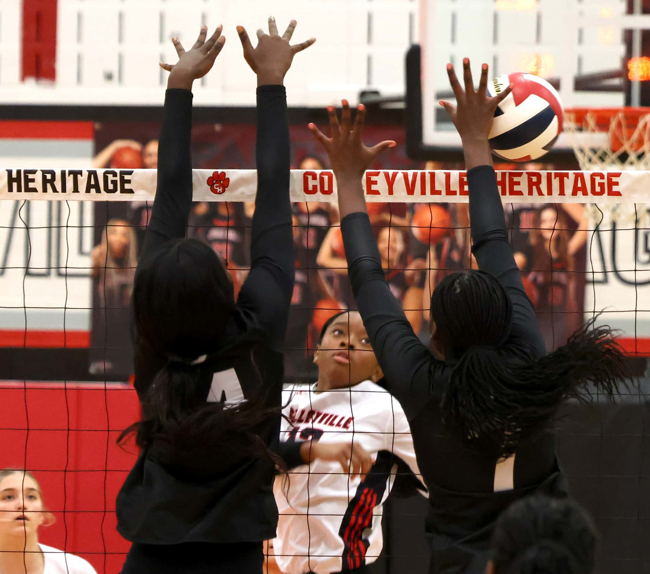 Colleyville Heritage Panthers' Maddy Mcculough (13), center background, scores past the...