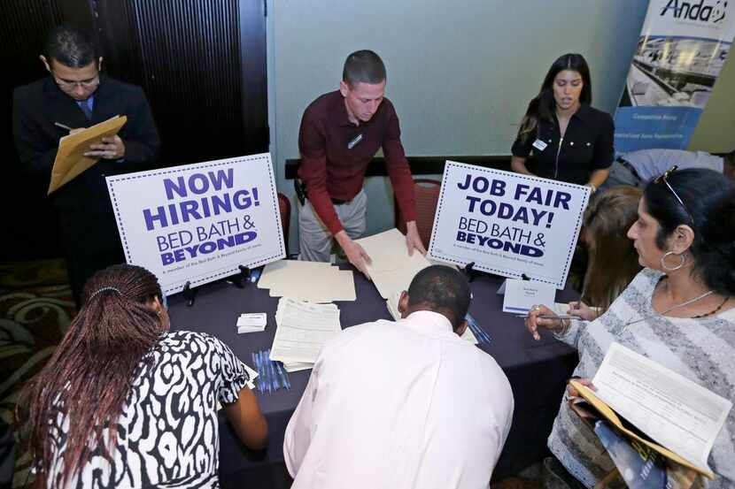 
Job seekers fill out applications at a job fair in Miami Lakes, Fla. Large oil and gas...