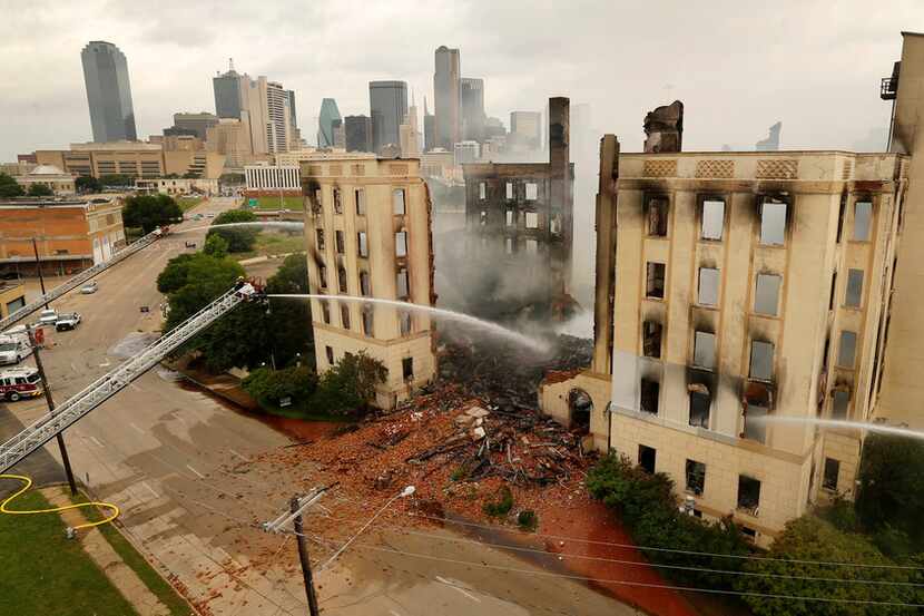 Dallas firefighters poured water on the destroyed historic Ambassador Hotel just south of...