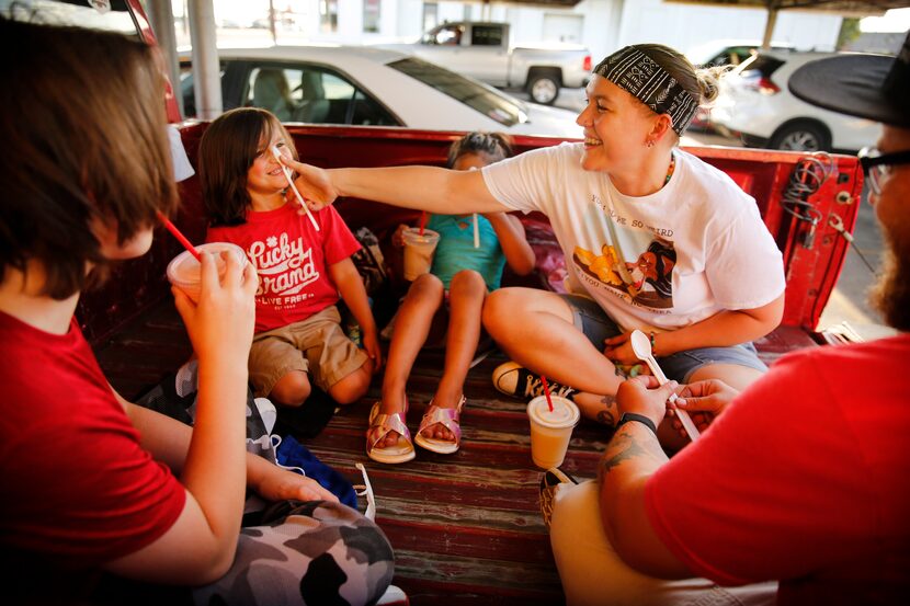 Erin Molina (facing, right) shows her son Ian Molina, 4, how to balance a spoon on his nose...