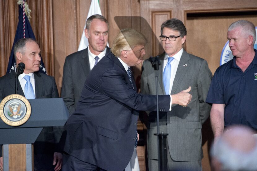 President Donald Trump gives a thumbs-up to the coal miners on the stage prior to signing an...