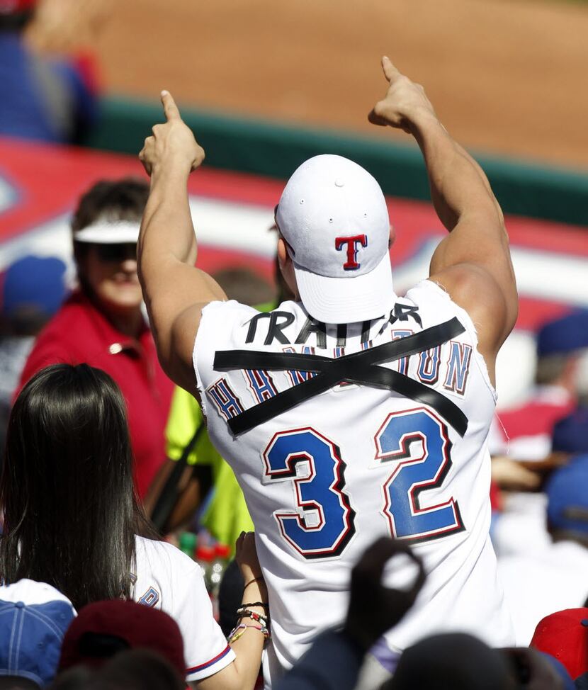 A Texas Rangers fan shows his pleasure as Los Angeles Angels left fielder Josh Hamilton (32)...