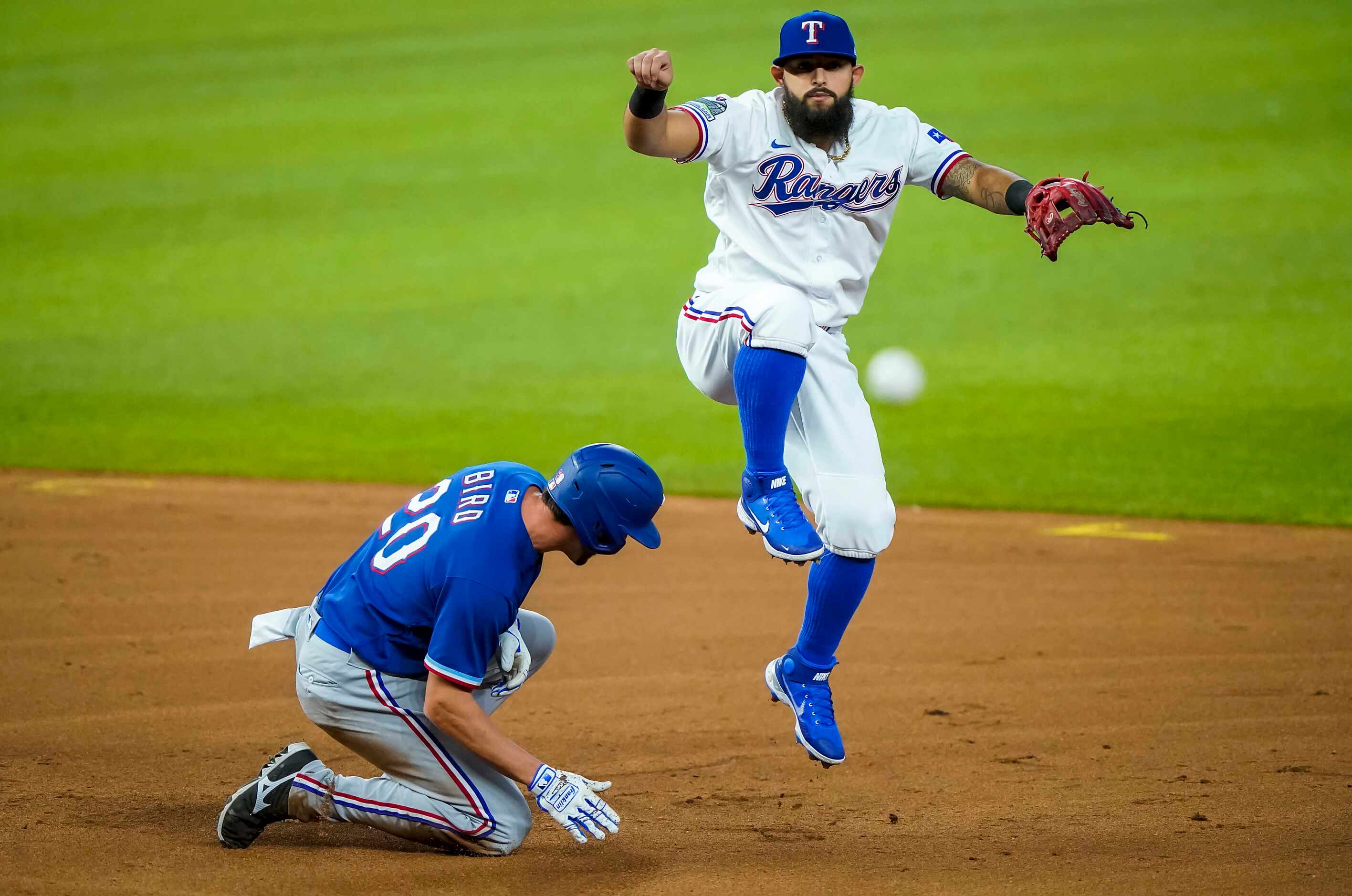 Second baseman Rougned Odor tries to compete a double play as he leaps over infielder Greg...