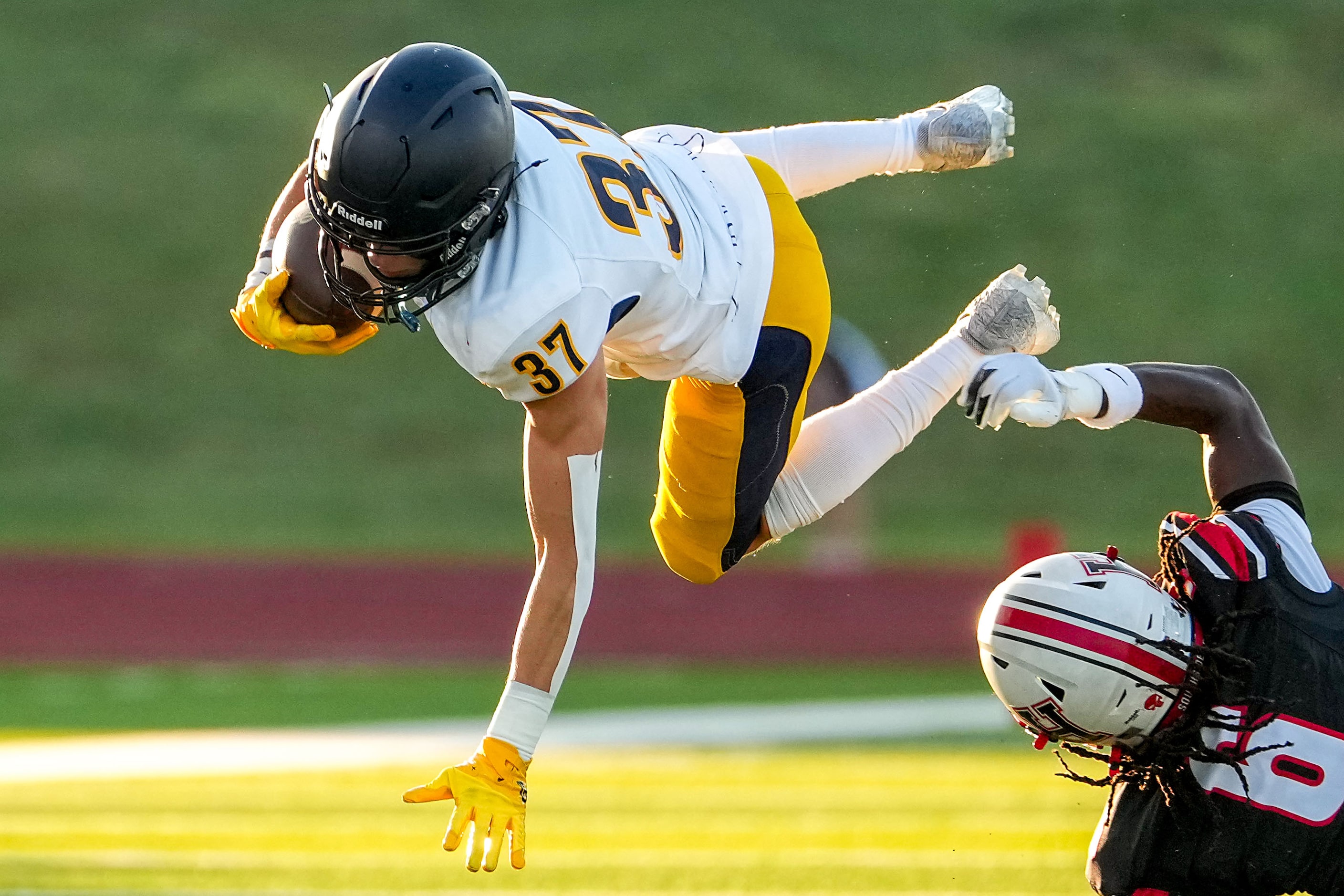 Highland Park wide receiver Cannon Bozman (37) is knocked off his feat by Rockwall-Heath...