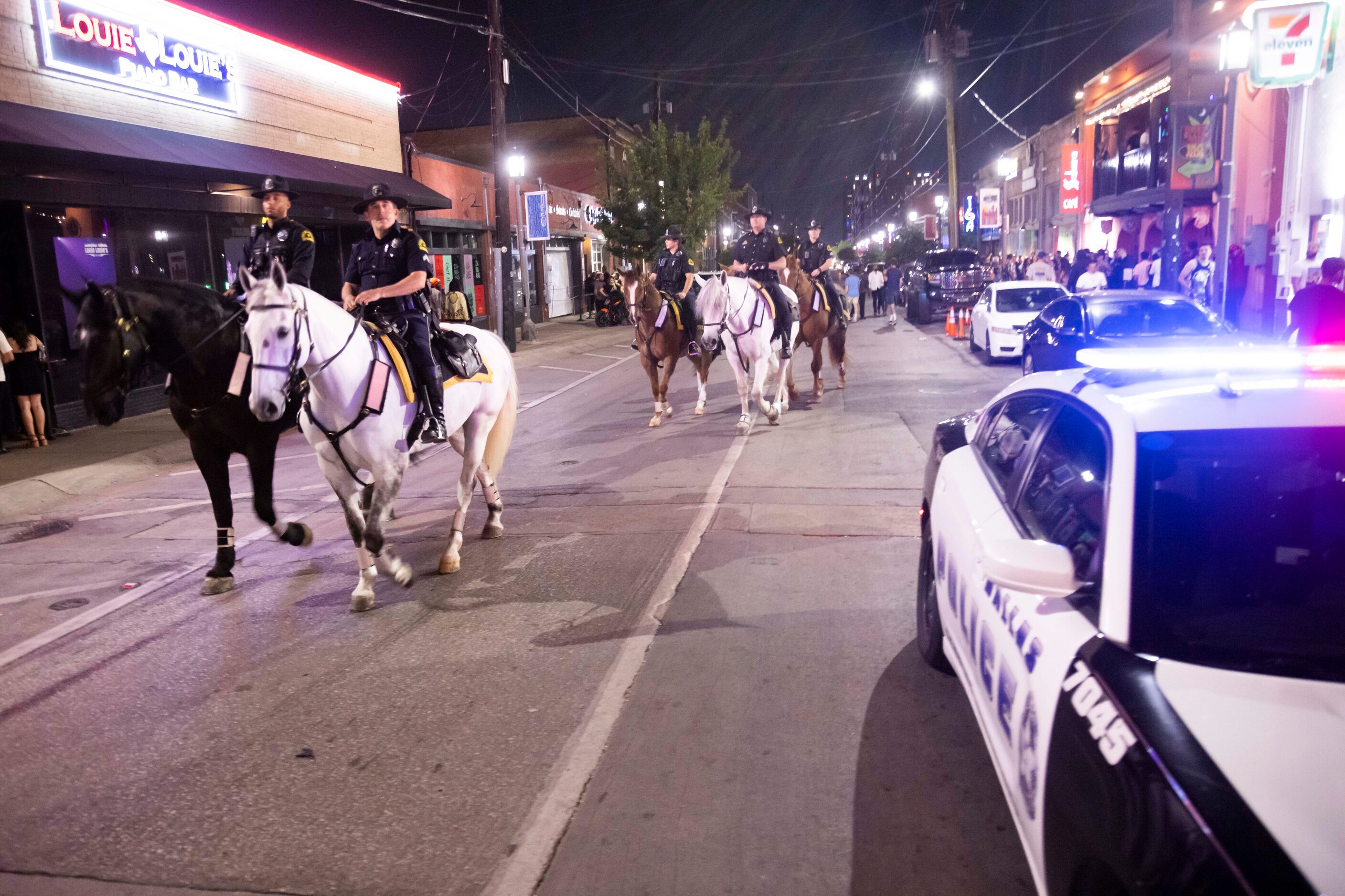 Dallas Police mounted officers ride down Elm Street in the Deep Ellum district of Dallas on...