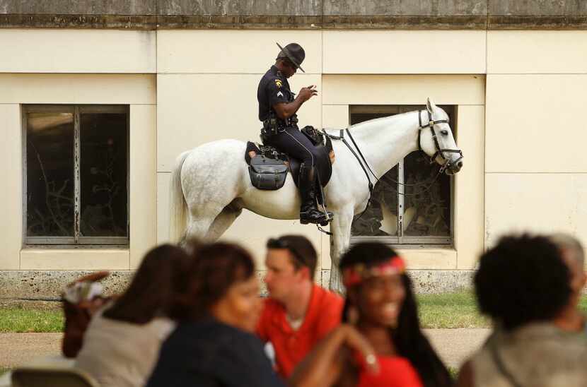 Dallas Police officer Andre Taylor patrols with the mounted unit behind the Texas Hall of...