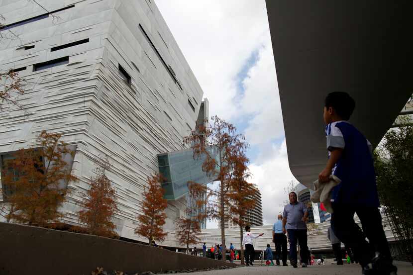 Visitors make their way toward the main entrance of the Perot Museum of Nature and Science...