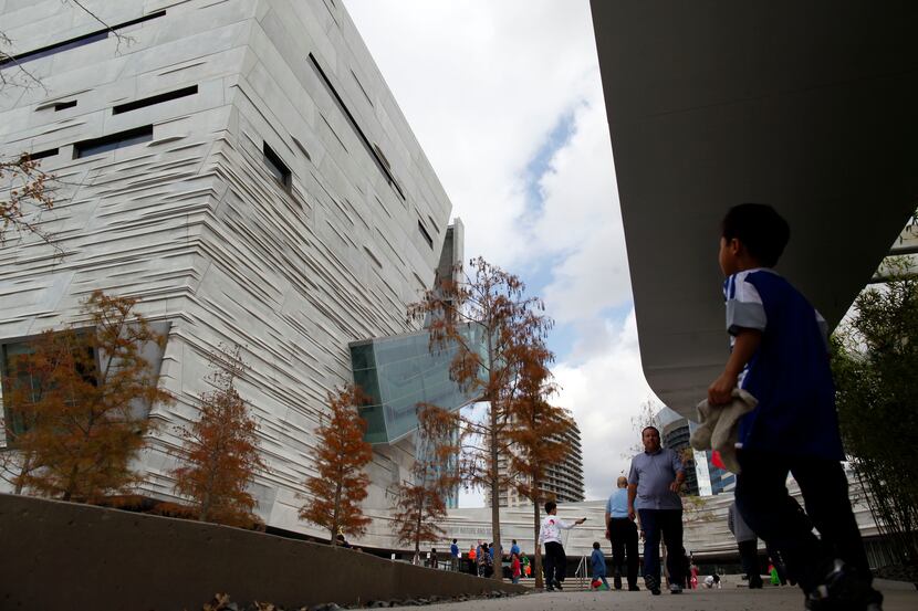 Visitors make their way towards the main entrance of the  Perot Museum of Nature and Science...