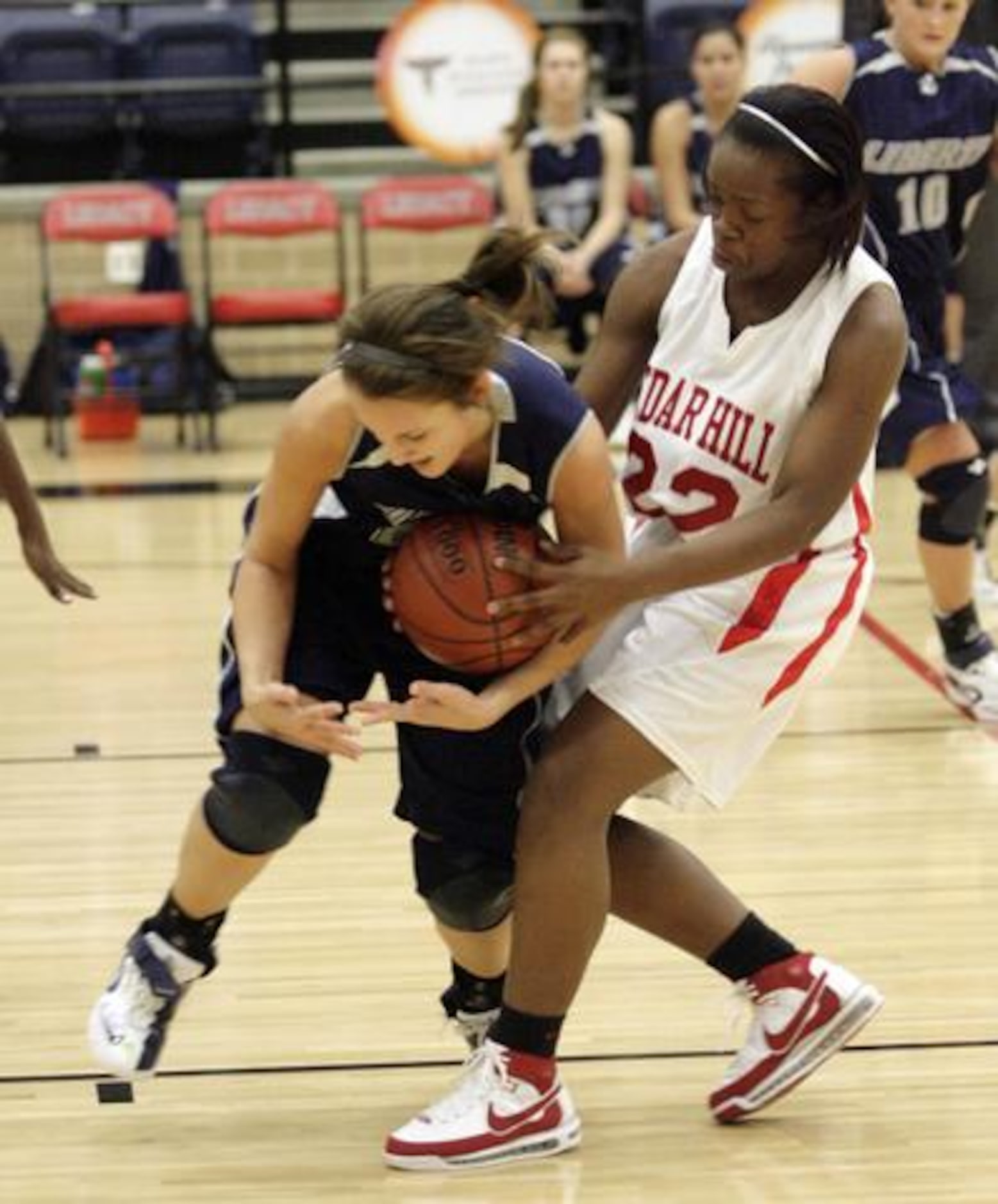 Argyle Liberty Christrian's Madison Middle (left) gets tied up by Cedar Hill senior forward...