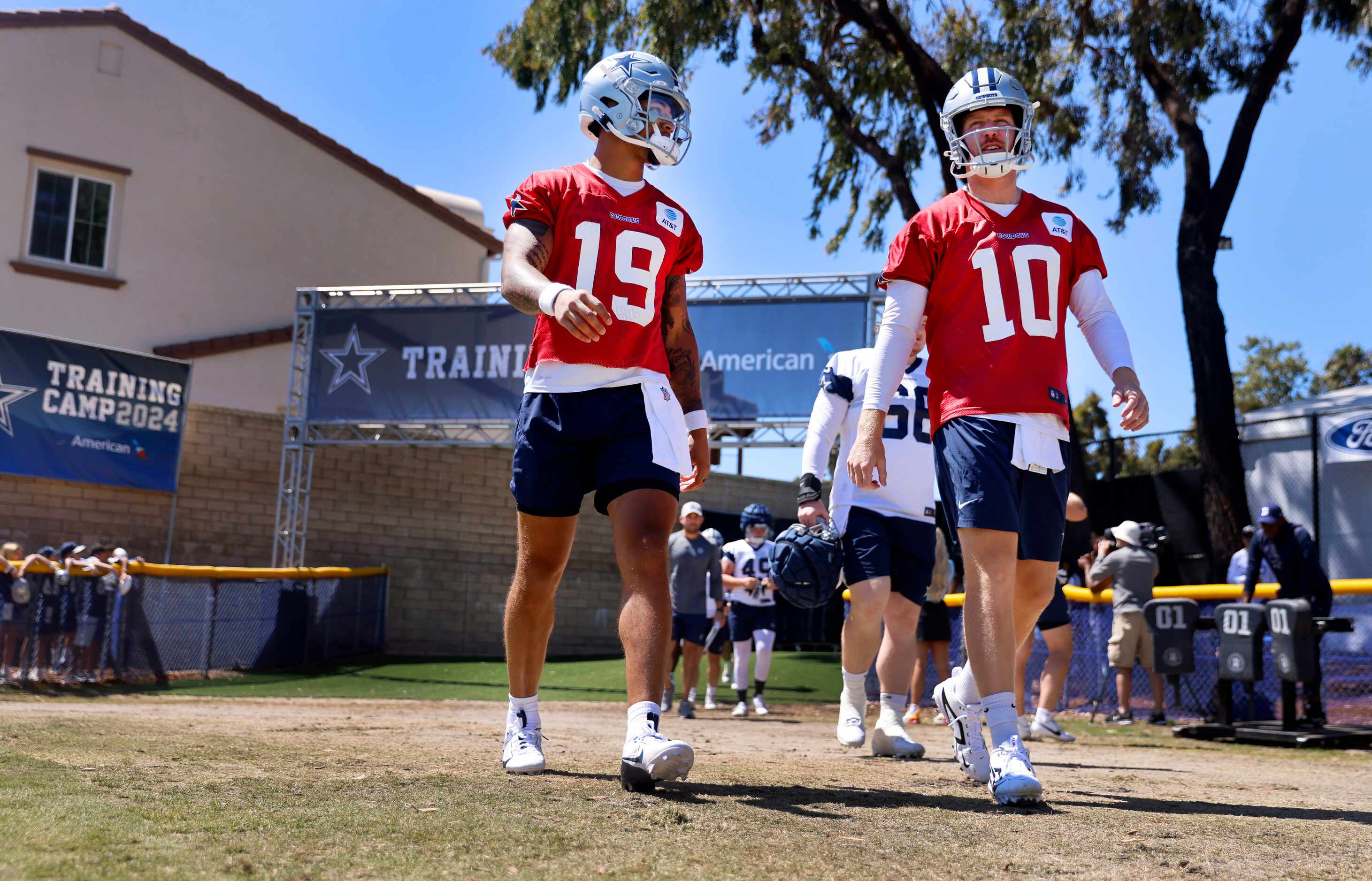Dallas Cowboys quarterbacks Trey Lance (19) and Cooper Rush (10) walk to the practice fields...