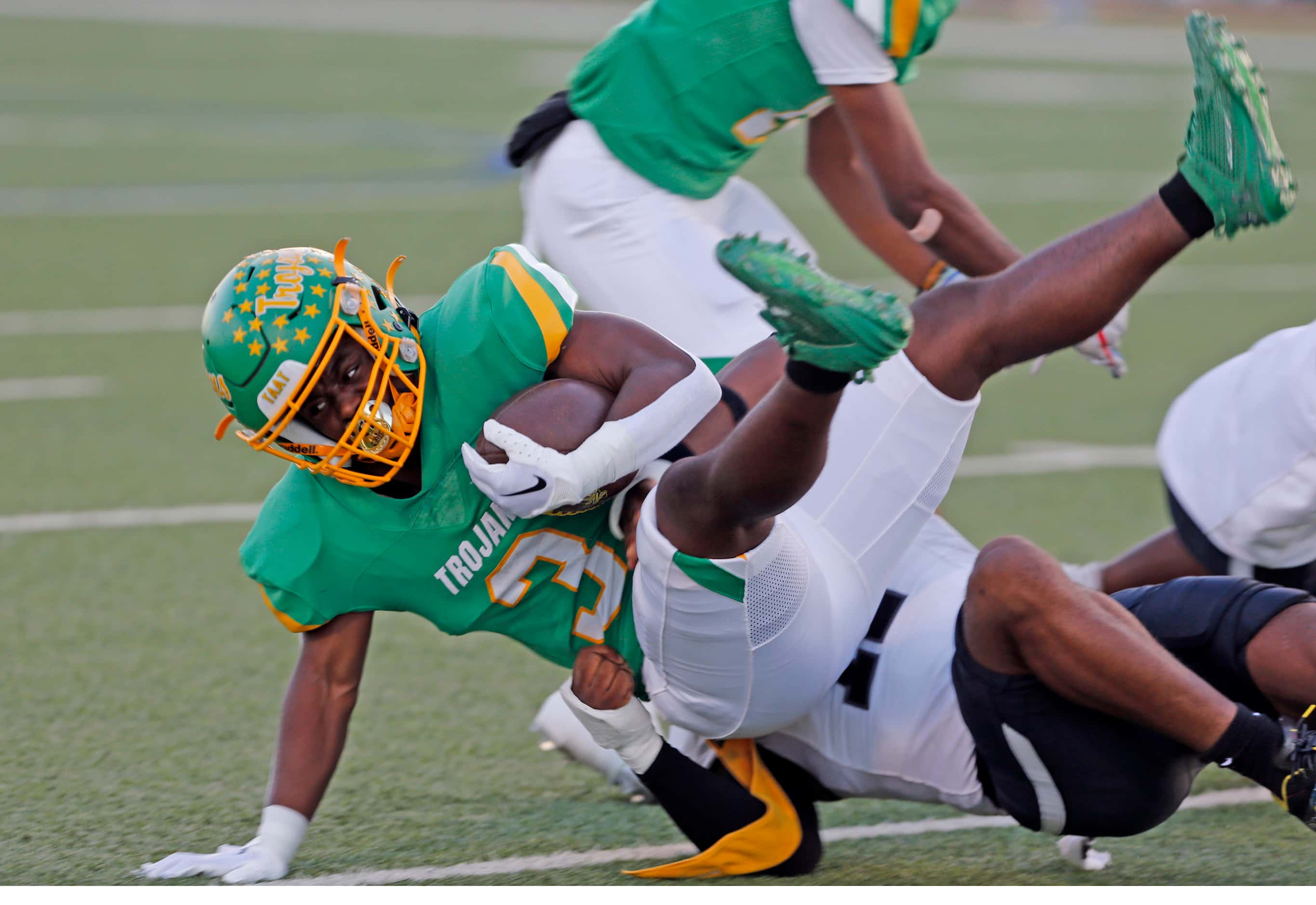 Newman Smith high’s Chris Hughes (3) is tackled by a Mansfield Timberview defender, after...