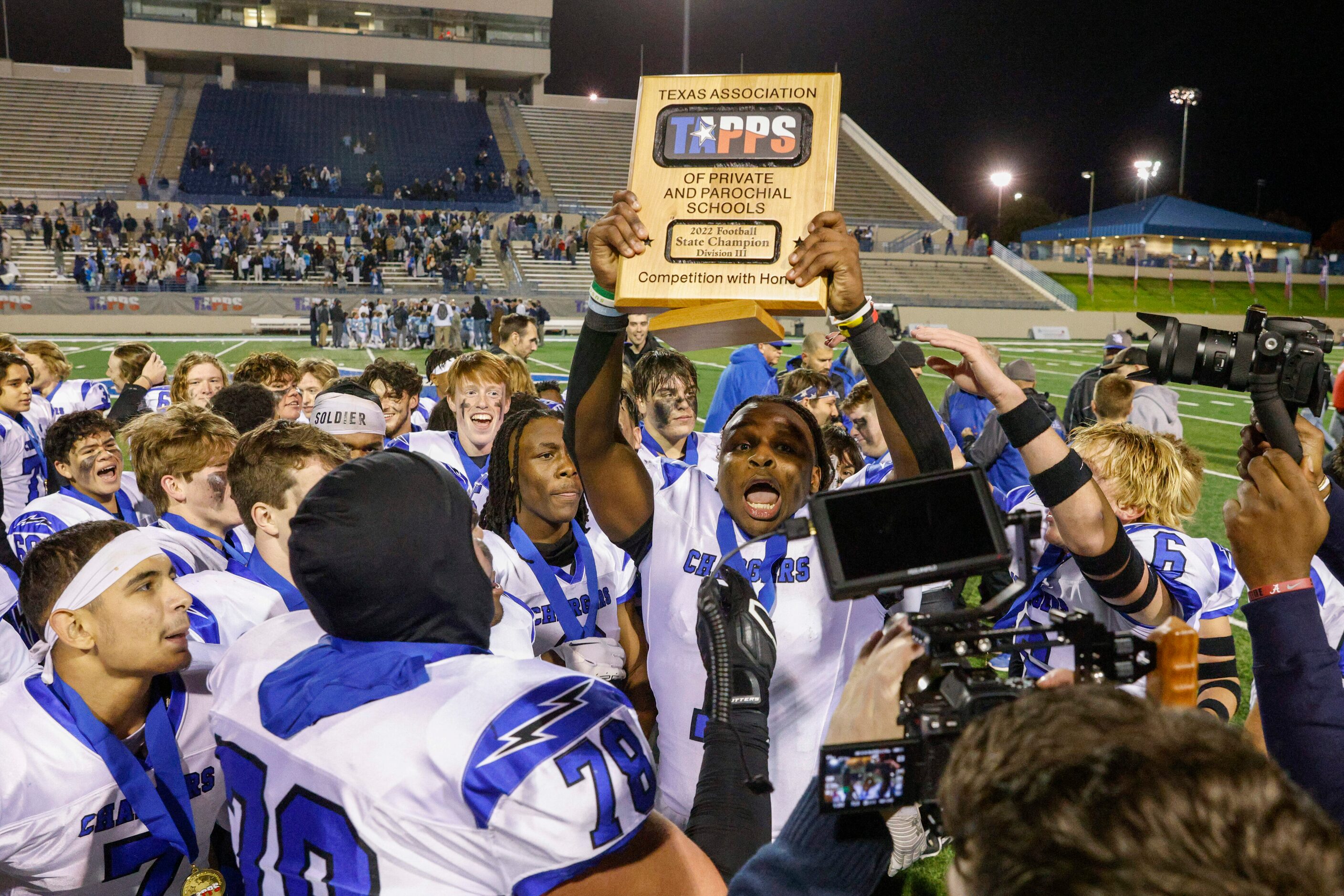 Dallas Christian running back Chris Scott (1) raises the TAPPS Division III state...