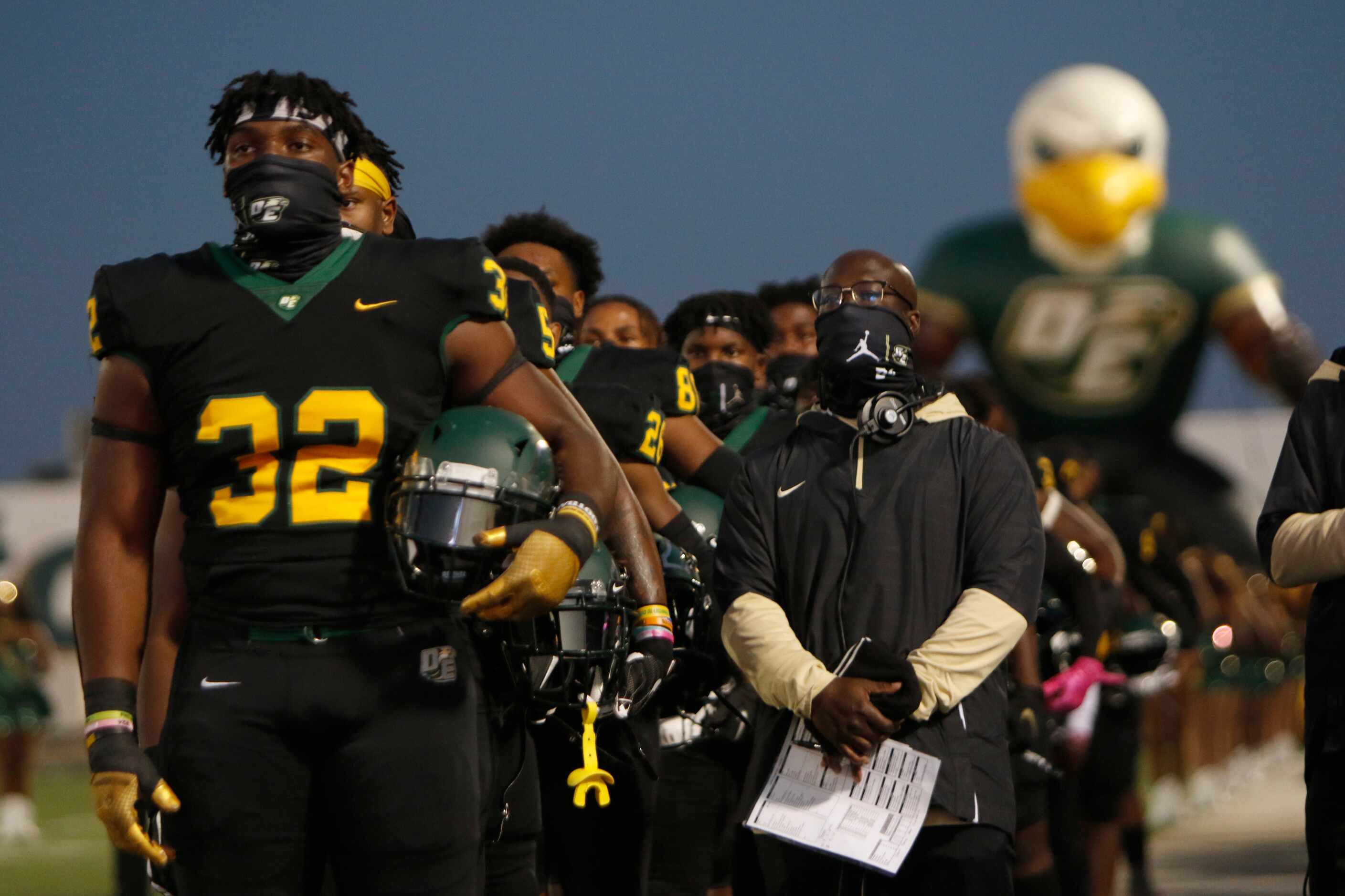 Shemar Turner (32) and the rest of the DeSoto Eagles pause for the playing of the national...