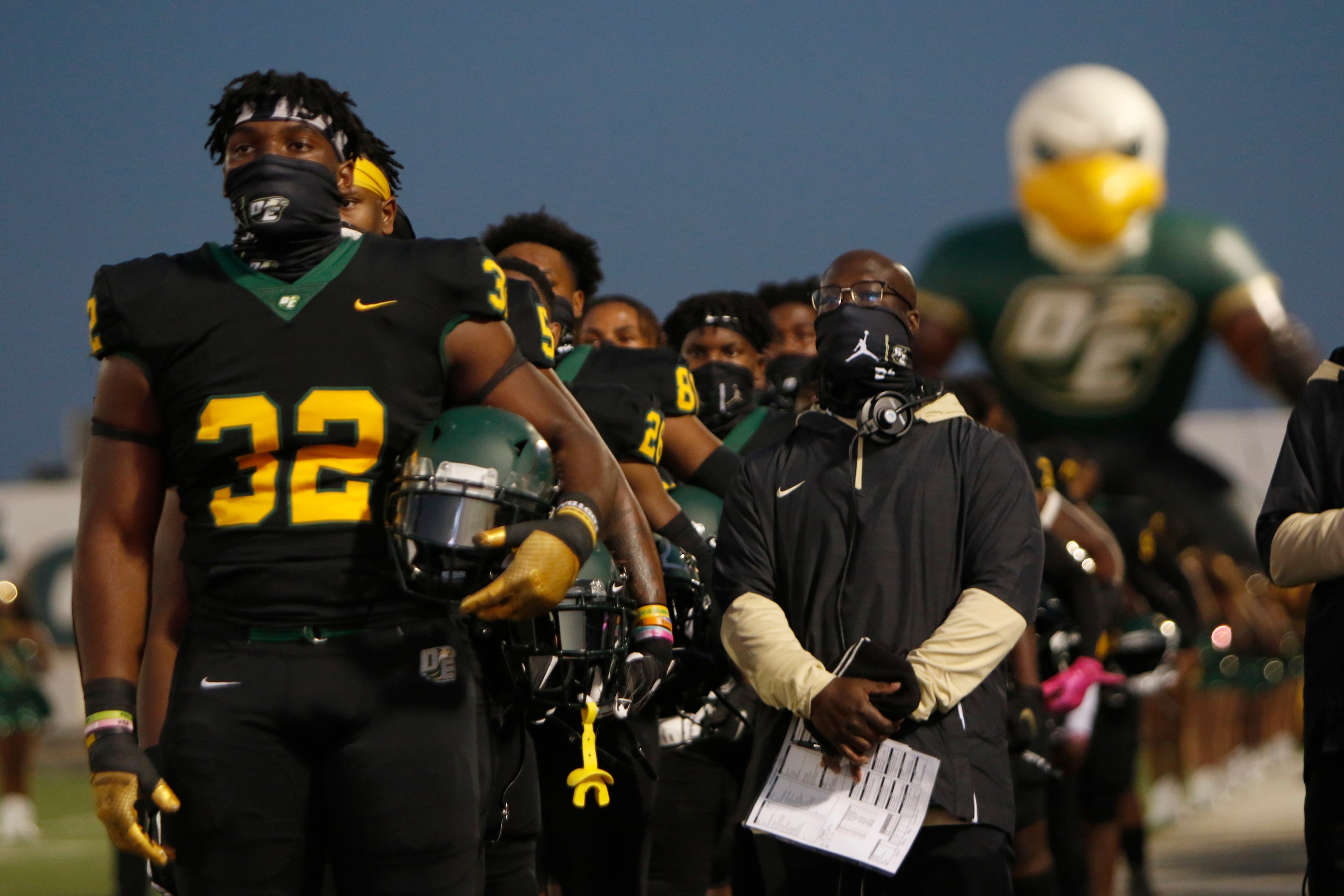 Shemar Turner (32) and the rest of the DeSoto Eagles pause for the playing of the national...