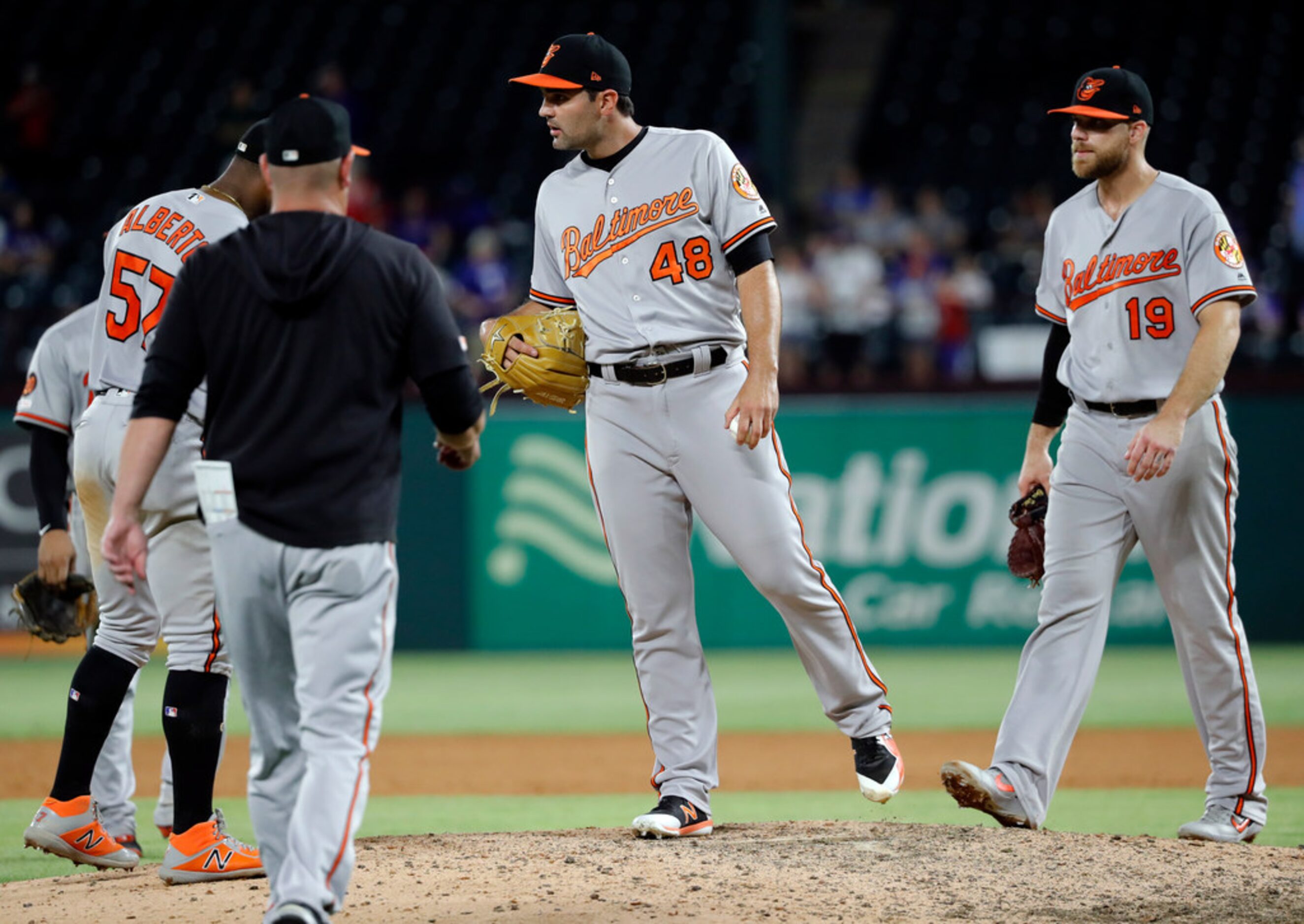 Baltimore Orioles manager Brandon Hyde, left front, walks out to take the ball from relief...