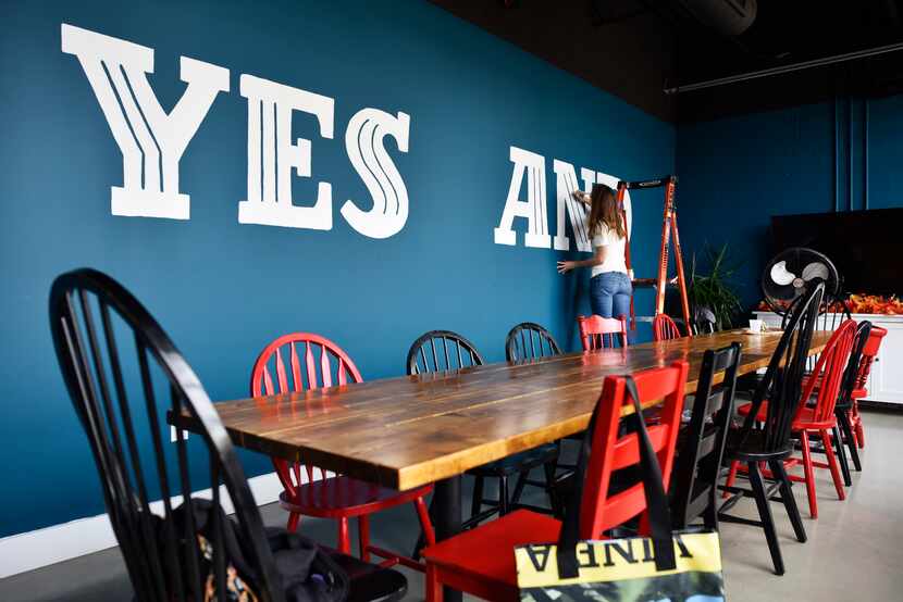 Amy DiCarlo, paints giant text inside the writer's room at the Dallas Comedy House in...