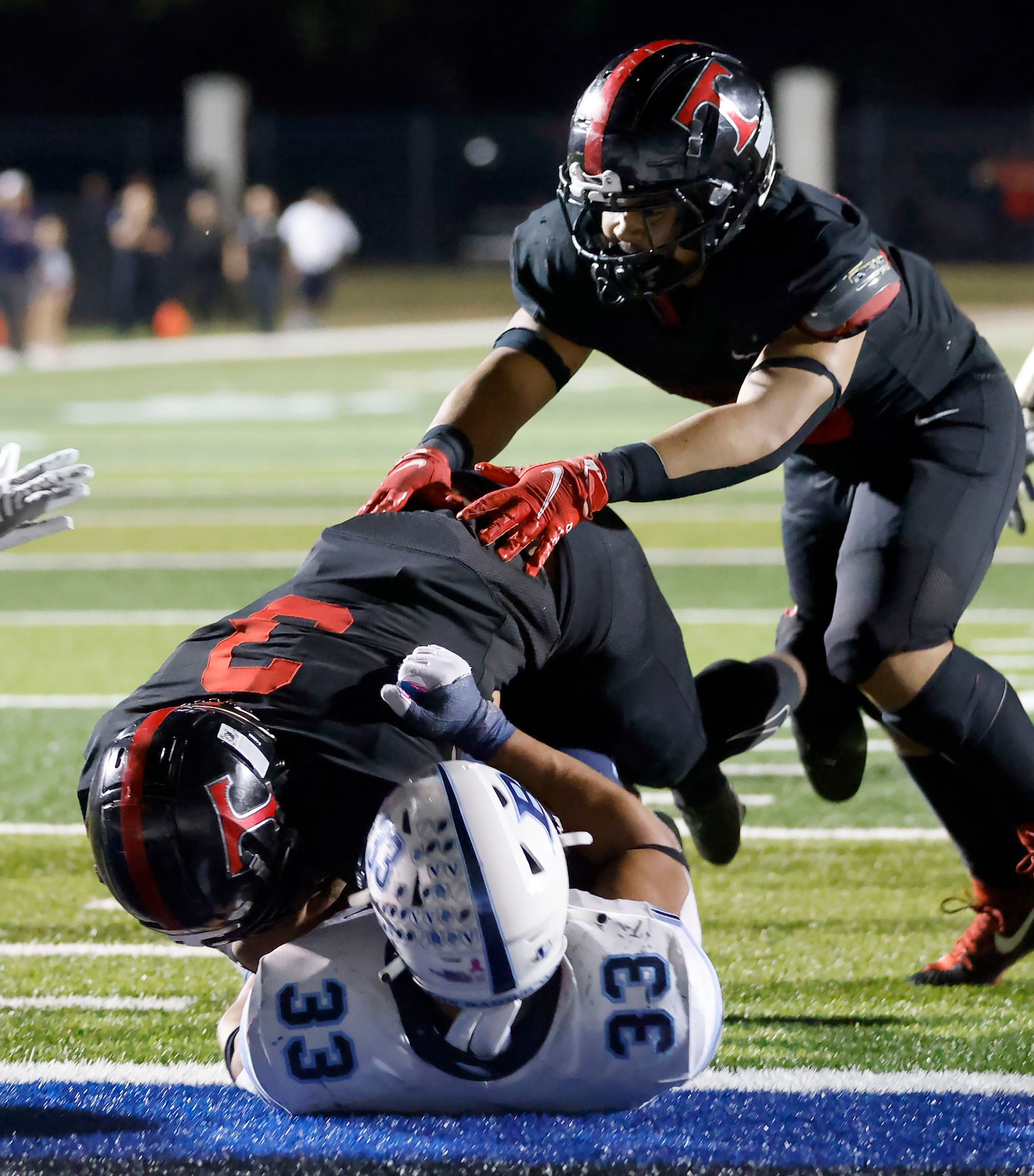 Euless Trinity running back Gary Maddox (3) runs over Hurst L.D. Bell linebacker Trey Wilson...