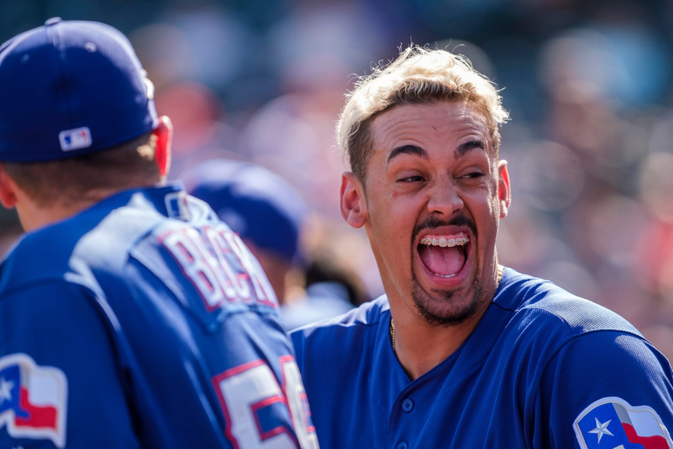 Texas Rangers first baseman Ronald Guzmân laughs with teammates in the dugout, including...