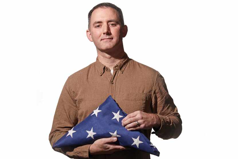 Jeremy Fusco, LCSW, holds an American flag folded in a triangle to honor veterans.
