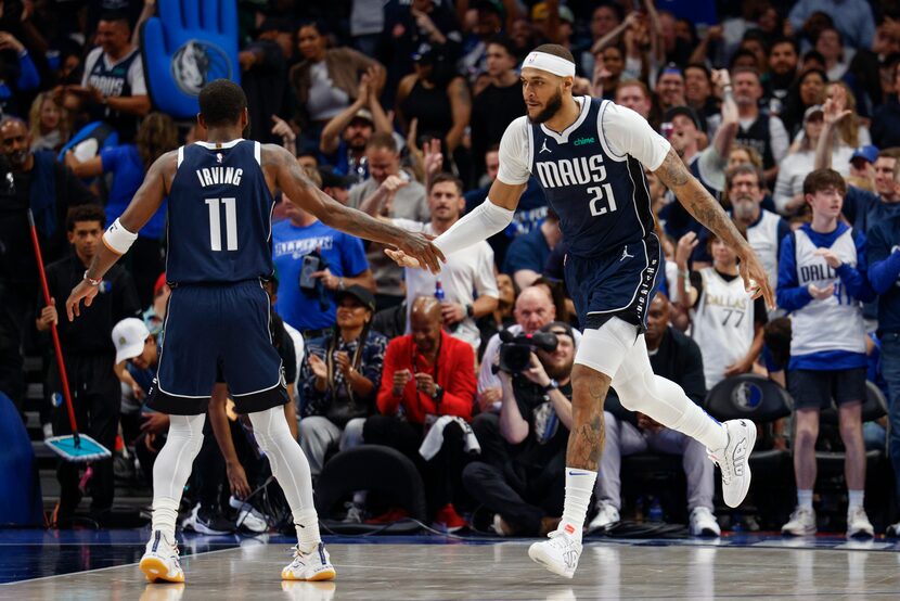 Dallas Mavericks center Daniel Gafford (21) high fives guard Kyrie Irving (11) during the...