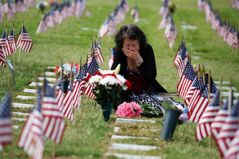 Una Pemberton, of Wichita Falls cries at the grave of her son, Clem J. Strait III, who...