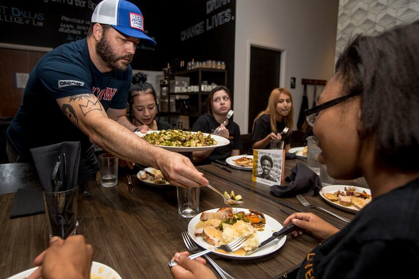 Founder Chad Houser dishes out Brussels sprouts to employee Zeslie, 16, during an employee...