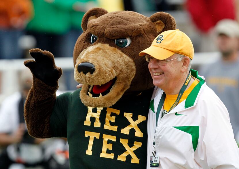 Baylor University Ken Starr takes a photo with the mascot before the start of a NCAA...