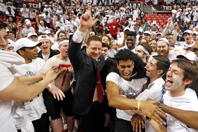 Texas Tech coach Chris Beard is surrounded by fans running onto the court after Texas Tech...