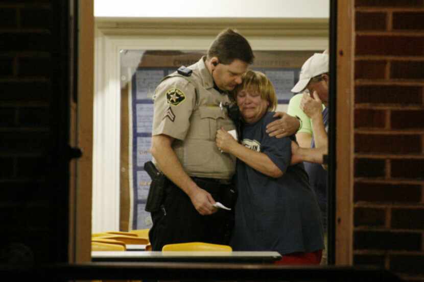 A woman is consoled by a sheriff's deputy at a command post in West on Thursday in the...