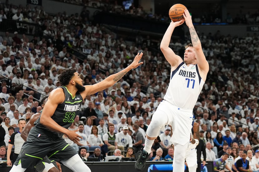 Dallas Mavericks guard Luka Doncic (77) shoots over Minnesota Timberwolves center...