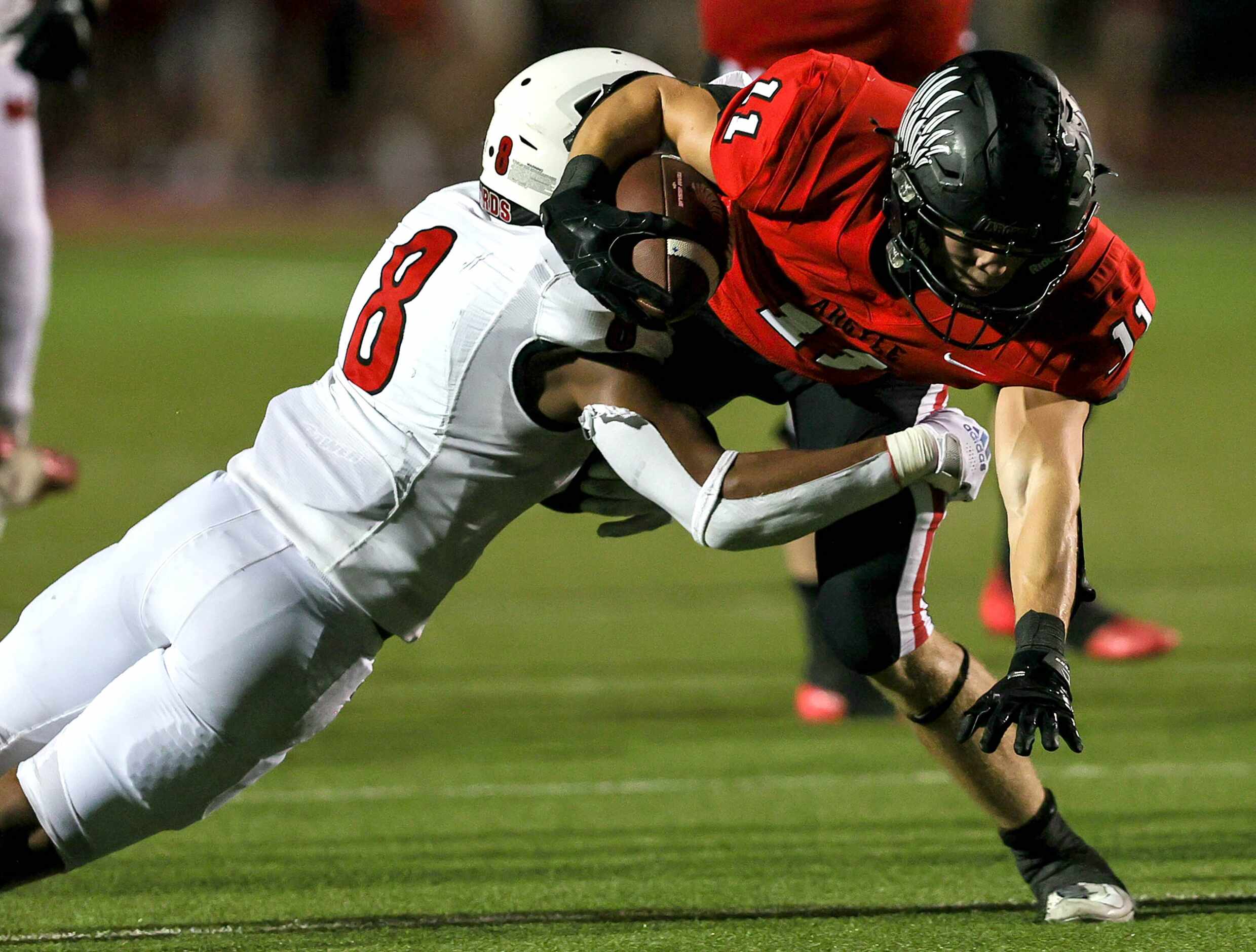 Argyle running back RJ Bunnell (11) fights for yardage against Melissa's Jacob Fields (8)...