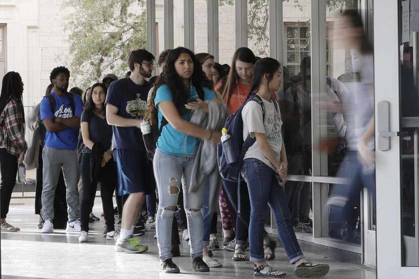 Un grupo de estudiantes hace fila para votar en un centro de votación en la Universidad de...