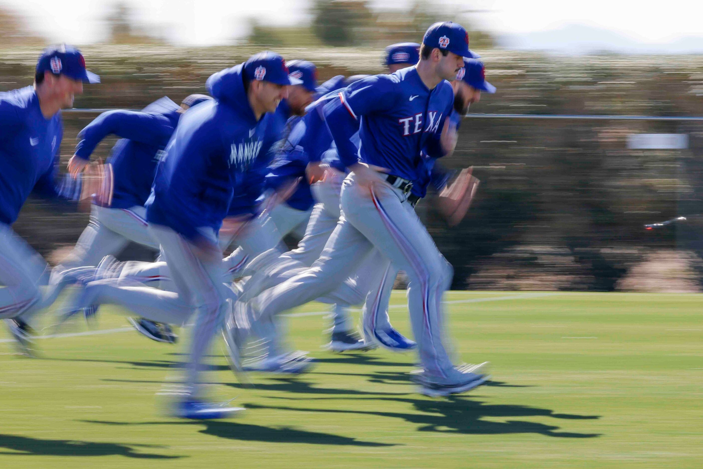 Texas Rangers players run during the first spring training workout for pitchers and catchers...