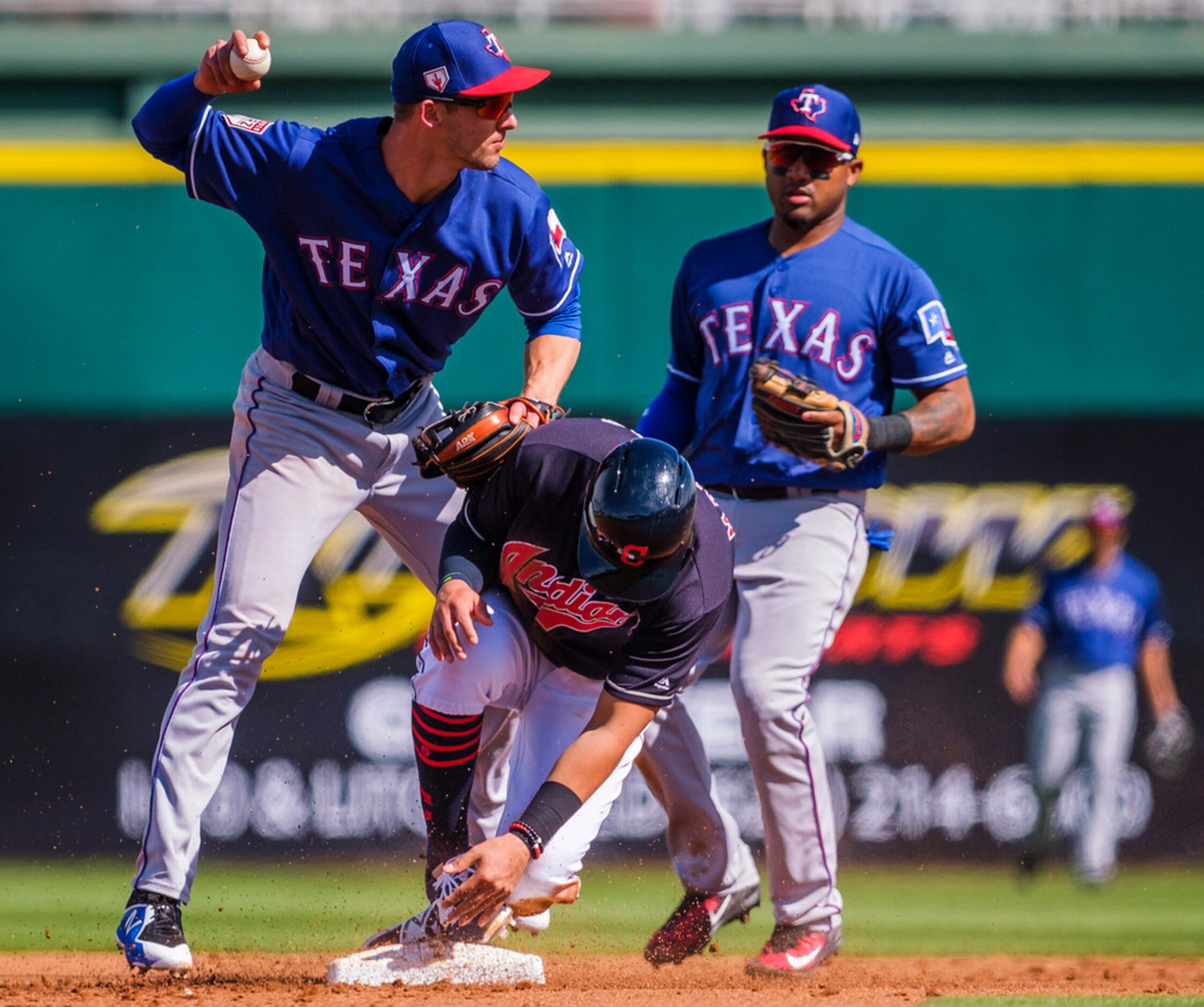 Texas Rangers infielder Eli White makes the relay over Cleveland Indians pinch runner Mark...