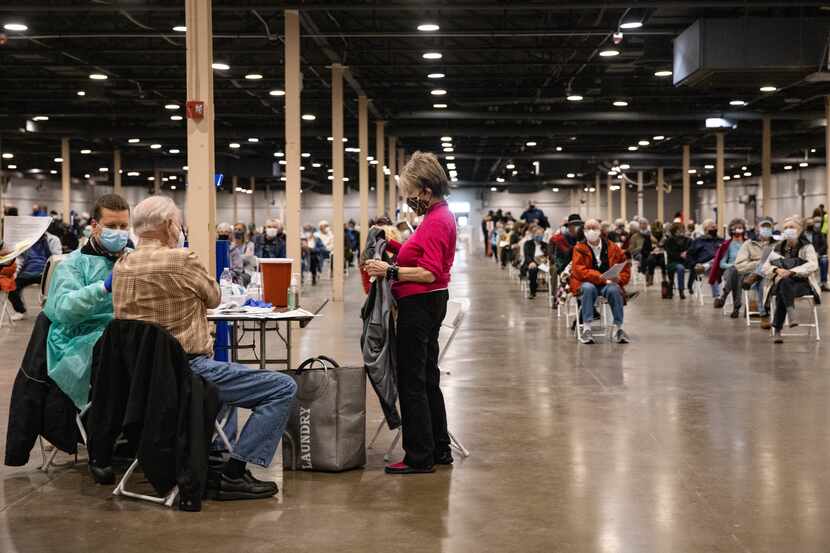 People wait to receive the COVID-19 vaccine at Fair Park in Dallas on Thursday, Jan. 14,...
