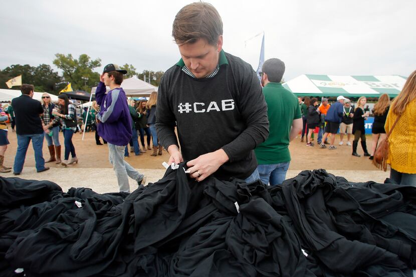 Jon McClellan of Houston surfs through a mound of shirts searching for a certain size before...