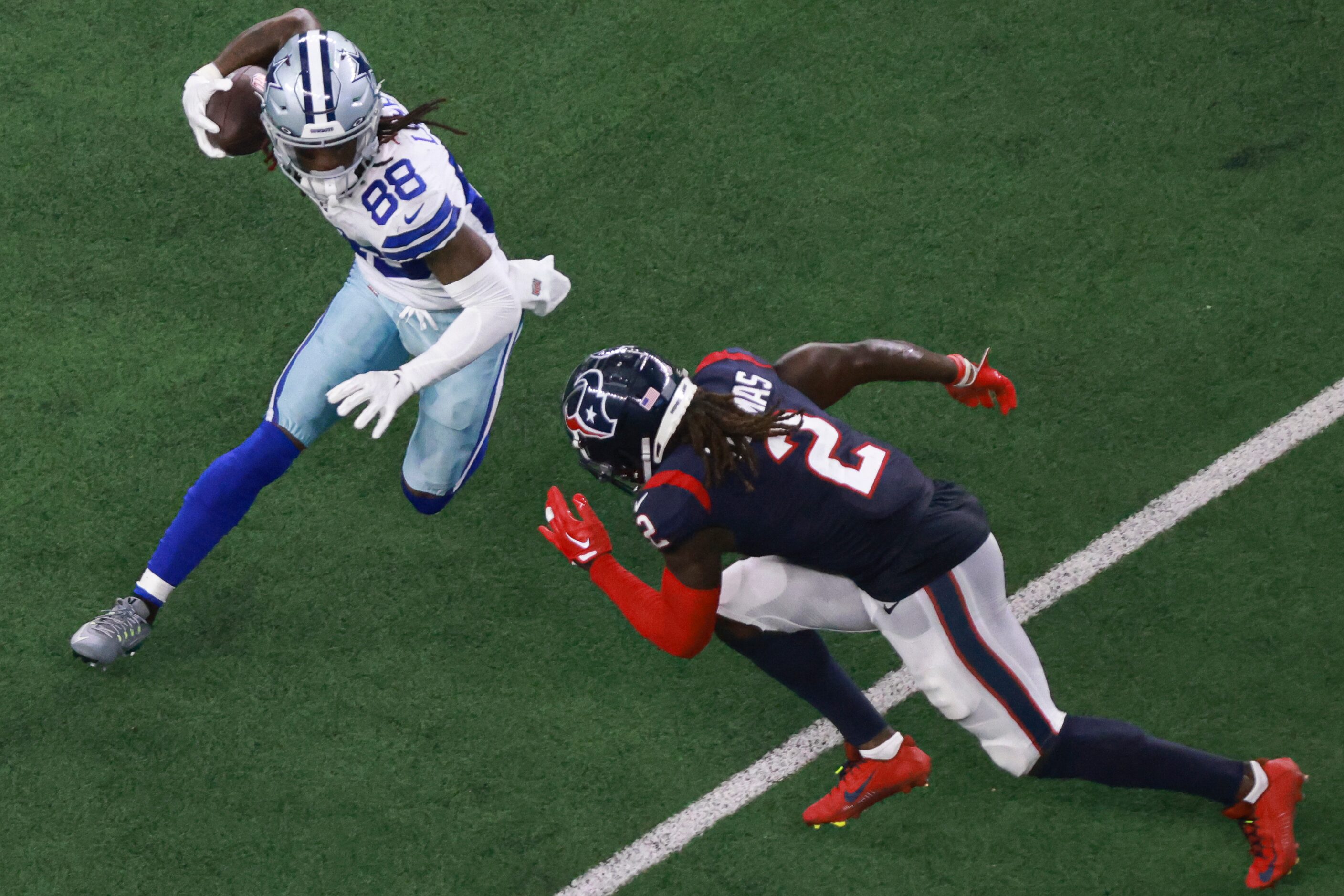 Dallas Cowboys wide receiver CeeDee Lamb (88) carries the ball up the field as Houston...