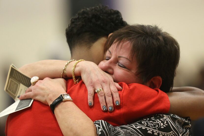 Bea Bonet, a principal at Madison East, hugs 17-year-old Shaun Daniels II during a funeral...