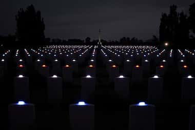Candles are lit on each tombstone of the Commonwealth war cemetery of...
