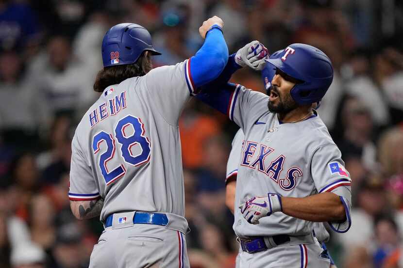 Texas Rangers' Marcus Semien, right, celebrates with Jonah Heim (28) after hitting a grand...