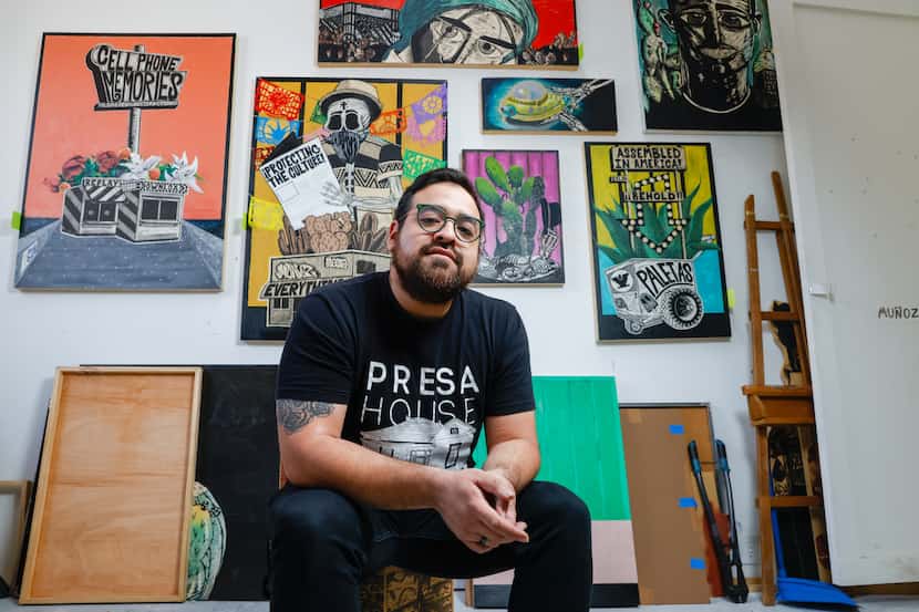 Benjamin Muñoz sits in front of some of his latest woodcut print works in his art studio at...