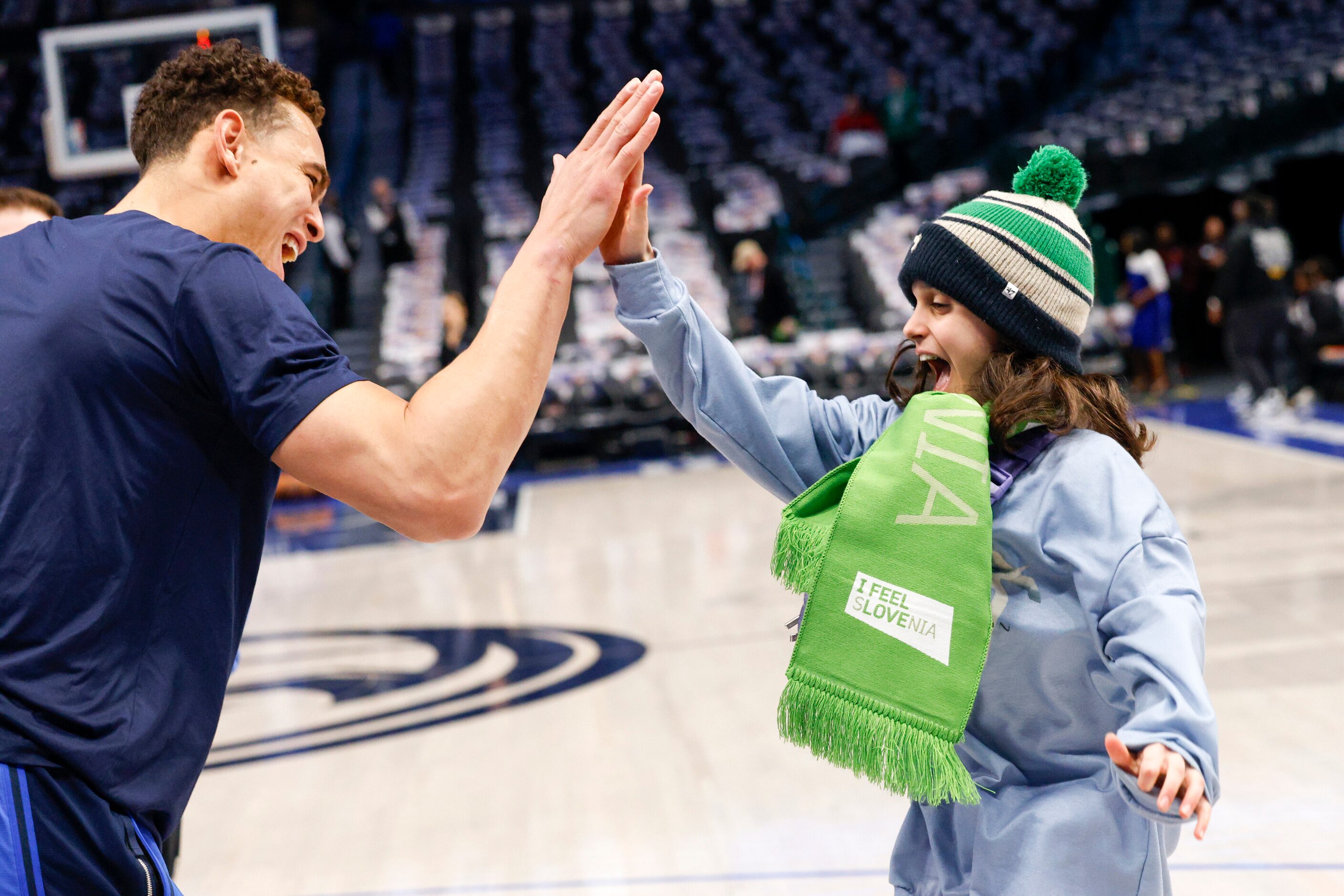 Dallas Mavericks center Dwight Powell high fives Layla Rowe, 11, after she threw him an...