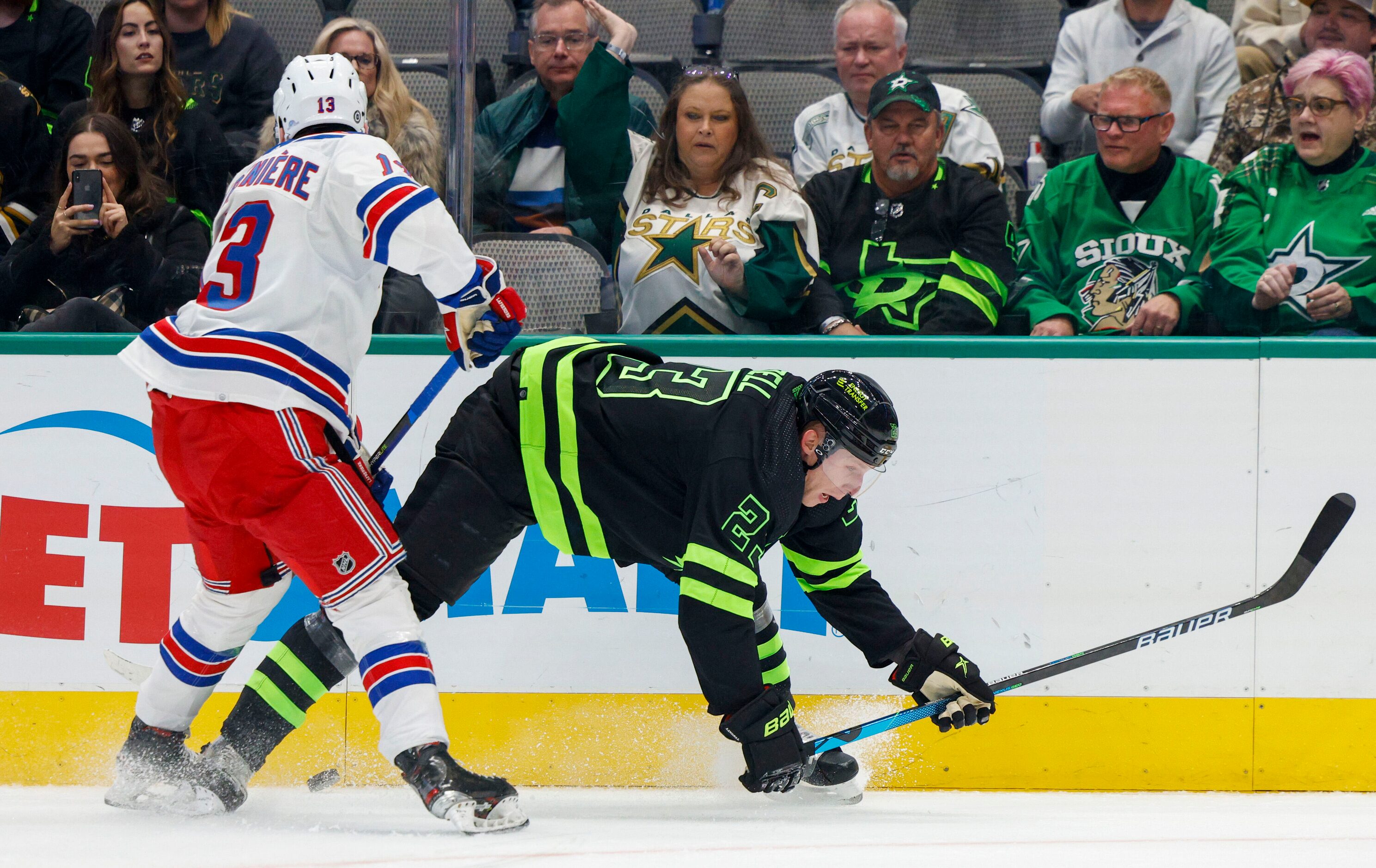 Dallas Stars defenseman Esa Lindell (23) falls to the ice alongside New York Rangers left...