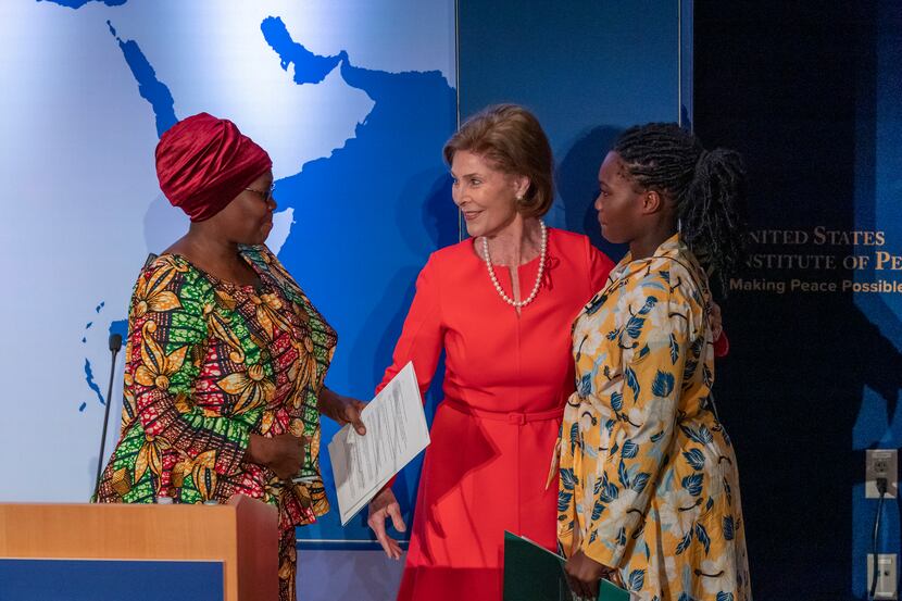 Former first lady Laura Bush greets AIDS patient Tatu Msangi, left, and her daughter Faith...