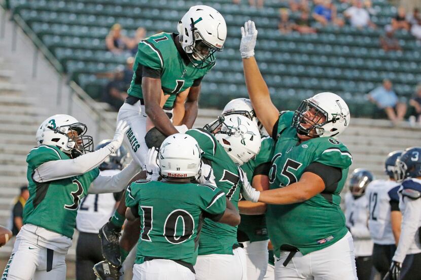 Poteet receiver Cha Cha Corbin (1) celebrates a touchdown reception with teammates during...