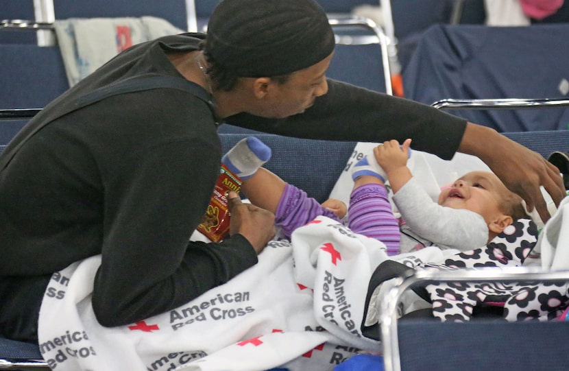 Displaced resident Darnyl Thomas plays with his daughter Riley Thomas as they try to pass...