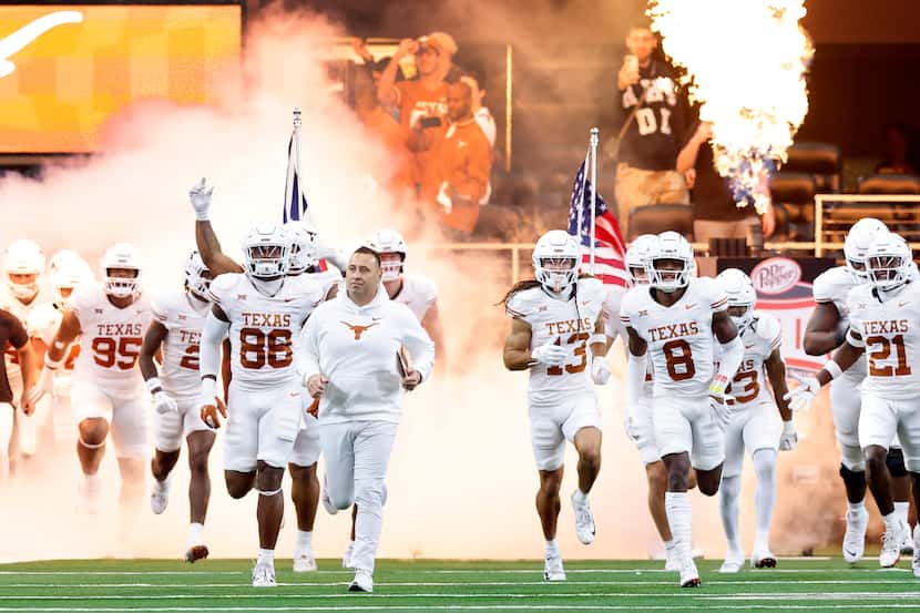 The Texas Longhorns football team races onto the field during team introductions before the...