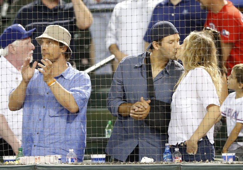 Dallas Cowboys quarterback Tony Romo and wife Candice Romo kiss in between innings at a...