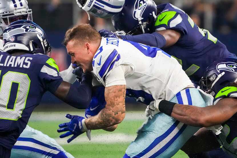Dallas Cowboys tight end Peyton Hendershot (49) has his helmet knocked off on a hit by...